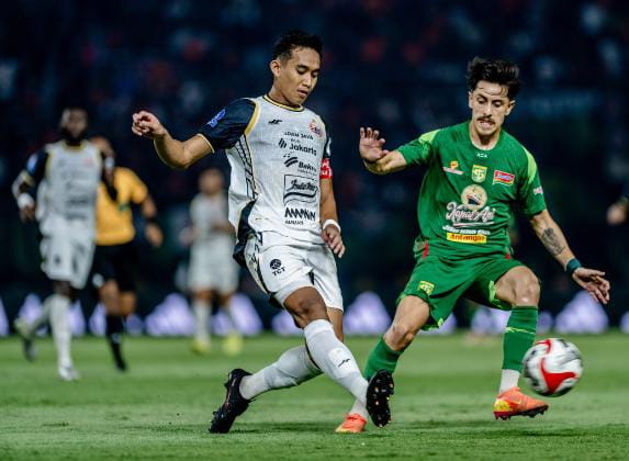 Bek Persija Rizky Ridho berebut bola dengan gelandang Persebaya Fransisco Rivera dalam partai Super League di Stadion GBT Surabaya, Minggu (19/10). (Foto: Istimewa)